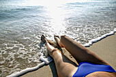 Frau im Bikini am Strand liegend, tiefer Ausschnitt