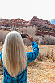 USA, Utah, Escalante, Woman taking photos in Grand Staircase-Escalante National Monument