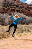 USA, Utah, Escalante, Frau springt vor Freude im Grand Staircase-Escalante National Monument