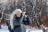 USA, Idaho, Bellevue, Ältere Frau mit Fernglas beim Wandern