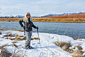 USA, Idaho, Bellevue, Senior woman snowshoeing at Silver Creek Preserve