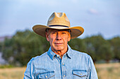 Porträt eines älteren Mannes in Jeanshemd und Cowboyhut