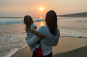 Mutter und Tochter (4-5) am Strand bei Sonnenuntergang