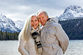USA, Idaho, Stanley, Portrait of smiling senior couple at mountain lake