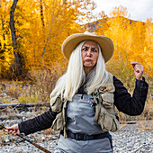 USA, Idaho, Bellevue, Senior woman holding fishing rod and making faces