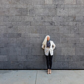 Portrait of senior woman leaning against wall