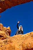 United States, Utah, Escalante, Senior hiker sitting on sandstone ledge