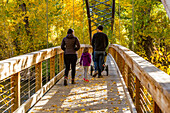 USA, Idaho, Hailey, Family crossing bridge in autumn