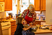 Großmutter und Enkelin (6-7) backen gemeinsam Kekse 