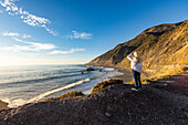 United States, California, Big Sur, Senior blonde woman looking at Pacific Ocean