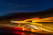 Unscharfes Bild von Lichtern auf dem Highway in der Dämmerung