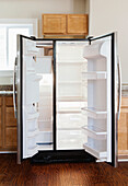 Leerer offener Kühlschrank in Wohnküche
