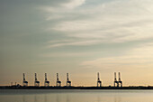 USA, Virginia, Shipping cranes in harbor at sunset