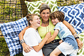 Mother with boy (8-9) and girl (16-17) in hammock