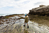 South Africa, Western Cape, Boy (8-9) exploring tidal pools in Lekkerwater Nature Reserve