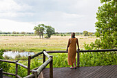 Africa, Northern Namibia, Woman on wooden walkway in Nambwa River Lodge