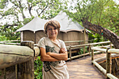 Africa, Northern Namibia, Portrait of boy (8-9) on wooden walkway in Nambwa River Lodge