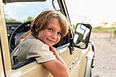 Boy (8-9) in safari vehicle, portrait