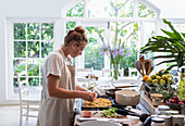 Girl (16-17) preparing meal in kitchen