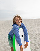 Junge (8-9) mit Bodyboard am Grotto Beach