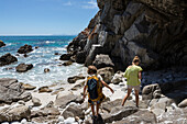 Südafrika, De Kelders, Mädchen (16-17) und Junge (8-9) erkunden felsige Atlantikküste