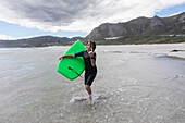 South Africa, Hermanus, Boy (8-9) with body board on Grotto Beach