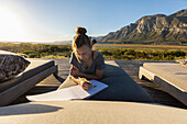 South Africa , Stanford, Girl (16-17) relaxing on deck, drawing in sketch pad