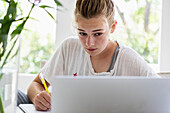 Mädchen (16-17) benutzt Laptop zu Hause