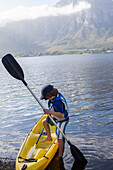 South Africa, Stanford, Boy (10-11) entering kayak in lagoon