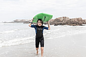 Junge (10-11) mit Bodyboard am Voelklip-Strand