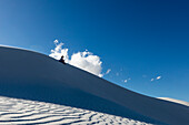 United States, New Mexico, White Sands National Park, Boy (10-11) sand boarding in desert