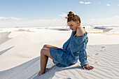 Vereinigte Staaten, New Mexico, White Sands National Park, Teenager-Mädchen sitzt auf Sand