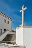 Portugal, Torres Novas, Kreuz auf weißer Kirche vor blauem Himmel