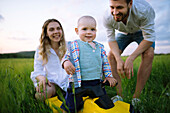 Parents with baby son (12-17 months) in agricultural field