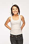 Studio portrait of smiling woman in white tank top