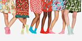 Beine einer Frau in bunten Kleidern und Socken