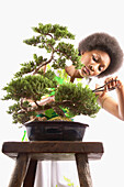 Frau beim Beschneiden eines Bonsaibaums