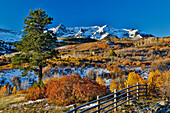 Dallas Mountain und San Juan Mountain Range, Colorado, Herbstfarben und goldglühende Espen mit Holzzaunlinie
