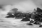 USA, New Jersey, Cape May National Seashore. Black and white of beach waves hitting rocks