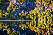 USA, New York State. Autumn reflections in Chapel Pond, Adirondack Mountains.