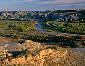 USA, North Dakota, Theodore Roosevelt National Park, Evening light on Valley of the Little Missouri River with sedimentary hills rising in the distance, from River Bend Overlook, North Unit.