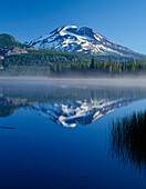 USA, Oregon, Deschutes National Forest, South Sister spiegelt sich im nebligen Wasser des Sparks Lake am frühen Morgen.