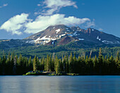 USA, Oregon, Deschutes National Forest, South side of Broken Top rises above coniferous forest and Sparks Lake in evening.