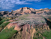 USA, South Dakota, Badlands National Park, North Unit, Pinnacles rise above grass and sedimentary formations near Dillon Pass.
