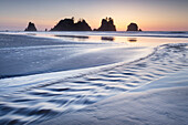 Dämmerung über dem Shi Shi Beach, in der Ferne sind die Felsen von Point of the Arches zu sehen. Olympic National Park, Bundesstaat Washington.