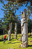 Photographer with totem pole at the UNESCO World Heritage Site at SGang Gwaay, Haida Gwaii, British Columbia, Canada, North America