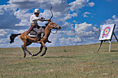 Kyrgyz nomad shooting arrows at a target while galloping, Song Kol lake, Naryn region, Kyrgyzstan, Central Asia, Asia