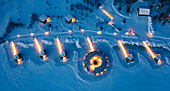 Die Kabinen des luxuriösen Arctic Bath Spa Hotels schwimmen in der Abenddämmerung auf einem zugefrorenen, schneebedeckten Fluss, Harads, Lappland, Schweden, Skandinavien, Europa