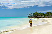 Mid adult man walking on empty sand beach, Nungwi, Zanzibar, Tanzania, East Africa, Africa