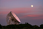 The Lovell Mark I Giant Radio Telescope at night with perfect alignment with the full moon, Jodrell Bank, Cheshire, England, United Kingdom, Europe